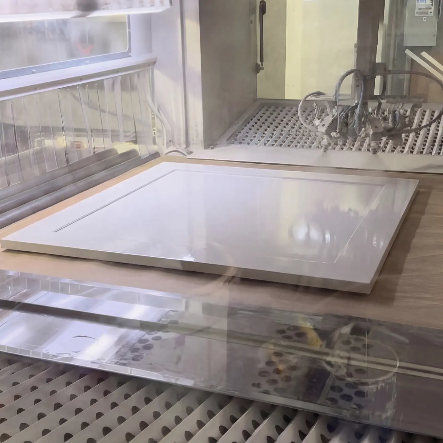 Kökslucka som lackeras i produktionen hos Sankt George med slitstark polyuretanbaserad möbellack