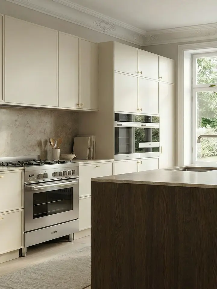 Mörkblå köksluckor med köksö i ek och ljusa golv