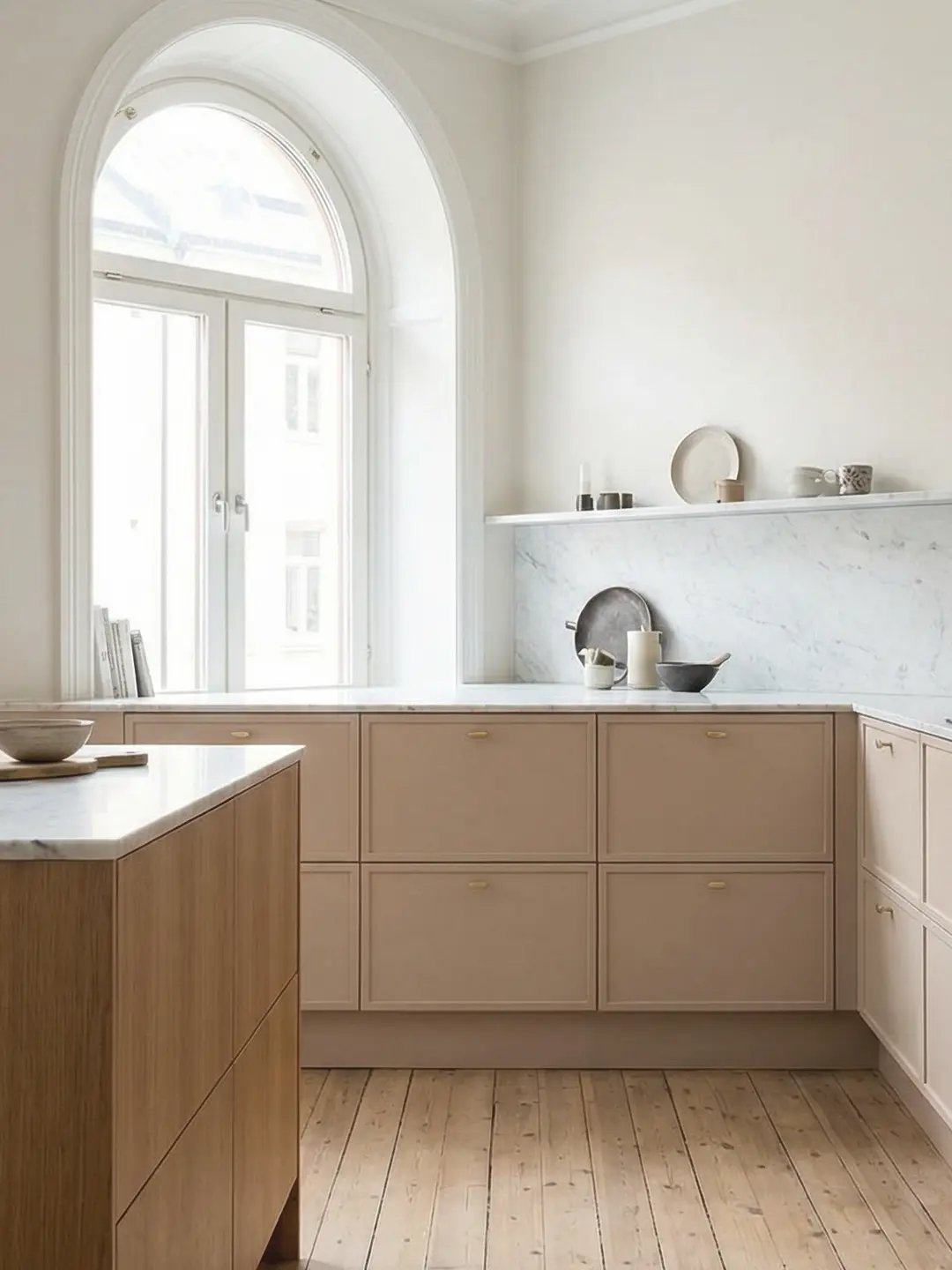 Kök med ramluckor i dämpad grön kulör, marmorbänkskiva och stora träfönster mot skog