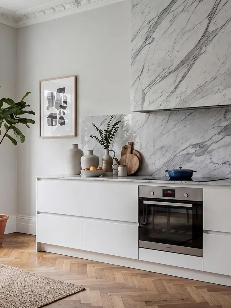 Flow köksluckor i Pure White med marmor, ljusa golv och nordisk design.