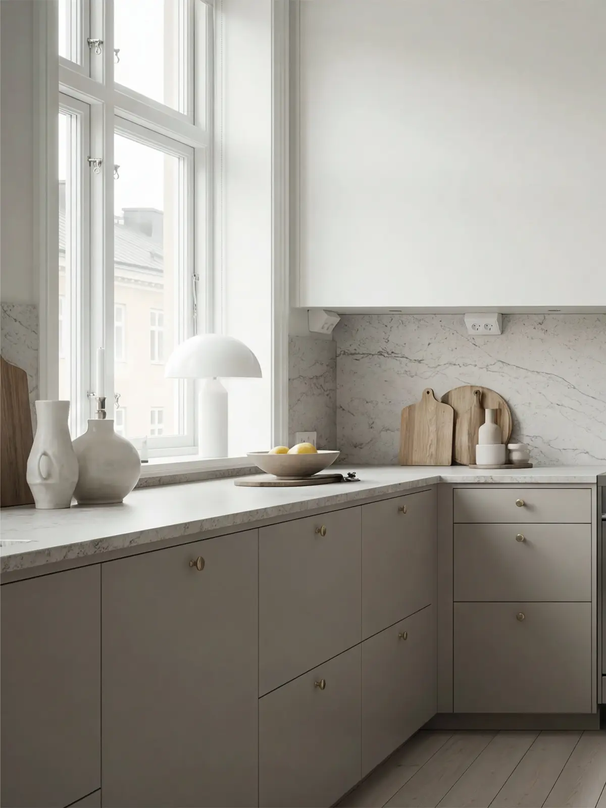 Detaljbild på Off Grey kökslådor i Pure med runda knoppar i mässing och ljus bänkskiva.
